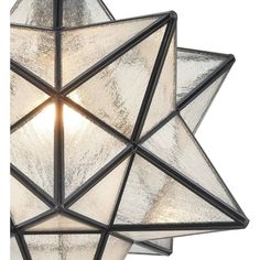 a light that is hanging from the ceiling with a star design on it's side