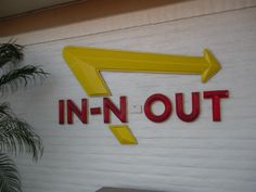 a sign on the side of a building that says in - n - out with an arrow