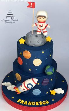 a birthday cake made to look like an astronaut on top of a rocket ship and planets