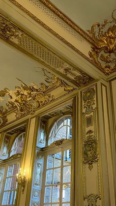 an ornate gold and white room with windows