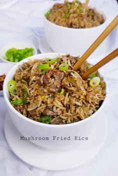 two bowls filled with rice and vegetables on top of a white tablecloth covered table