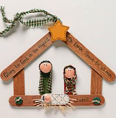 christmas ornament with two people in a manger and star on the roof