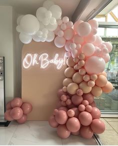 there is a bunch of balloons in front of the sign that says oh baby on it