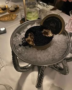 there is a cake on top of some ice in the middle of a table with wine glasses