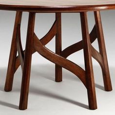 a round wooden table with curved legs