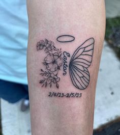 a tattoo on the leg of a person with a butterfly and flowers in front of it