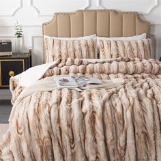 the bed is made with fur and pillows on top of it, along with two nightstands