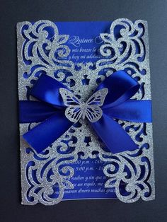 a blue and silver wedding card with a butterfly on the front, bow at the top