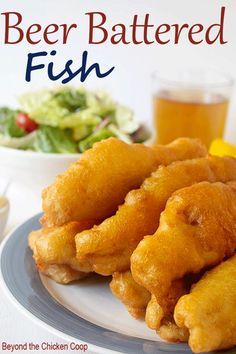 beer battered fish served on a plate with salad and drink in the backgroud