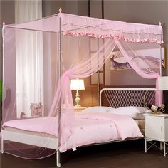 a pink canopy bed in a bedroom next to a night stand