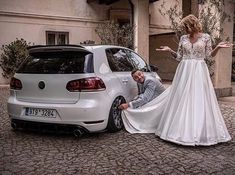 a man and woman standing next to a white car