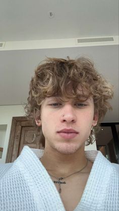 a close up of a person wearing a sweater and posing for a photo with his hair in the air