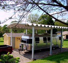 an rv is parked under a white awning