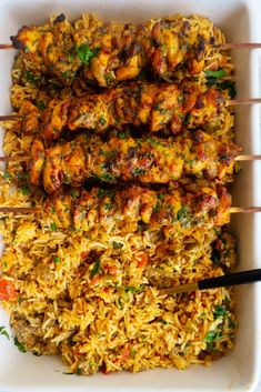 chicken and rice skewers in a white dish