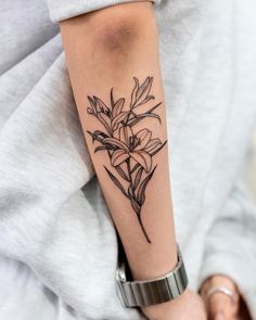 a woman's arm with a flower tattoo on the left side of her arm