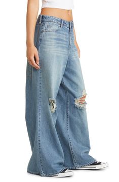 These baggy wide-leg jeans are designed with edgy knee rips and dramatic wide legs. 31" inseam; 29" leg opening; 14" front rise; 15 1/2" back rise (size 29) 70% cotton, 30% rayon Machine wash, tumble dry Imported Edgy Wide Leg Flare Jeans With Relaxed Fit, Edgy Wide Leg Flare Jeans For Streetwear, Edgy Wide-leg Flare Jeans For Streetwear, Edgy Baggy Wide Leg Jeans, Edgy Wide Leg Jeans With Relaxed Fit, Edgy Baggy Wide Leg Cargo Jeans, Distressed Baggy Wide Leg Bottoms, Baggy Wide Leg Distressed Bottoms, Distressed Wide Leg Baggy Bottoms