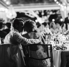 a man and woman sitting at a table in front of a group of other people