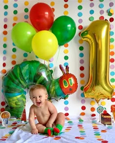 a very cute baby sitting in front of some balloons