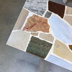 a close up of a table made out of different types of wood and stone tiles