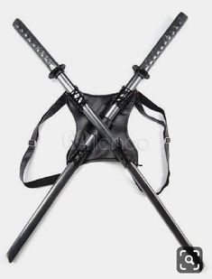 two crossed swords are attached to the back of a black leather bag with straps on it