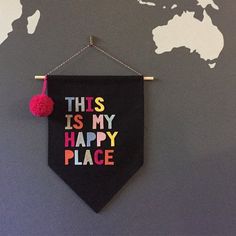 this is my happy place banner hanging on the wall with a world map in the background