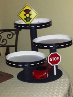 there is a stop sign and three plates on the table that are shaped to look like cars