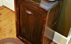 a small wooden cabinet sitting on top of a hard wood floor next to a door