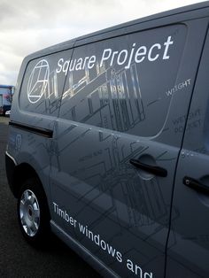 a van parked in a parking lot next to other cars and trucks with the word square project written on it