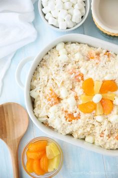 a bowl filled with rice, carrots and marshmallows on top of a blue table