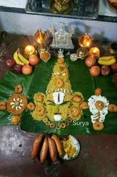 an arrangement of food on a leaf with candles and other items around it in the background