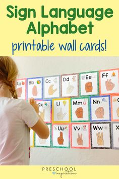 a girl holding up a sign language alphabet printable wall cards