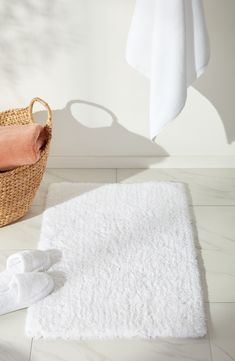 a bathroom with a basket and towels on the floor next to it's bath mat