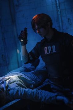 a man sitting on top of a bed in a dark room with his arm up