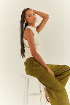 Woman sitting on a white stool in a white high-neck tank top and a pair of olive silky cargo pants. Fall Staples, Cargo Pant, Satin Fabric, Stylish Design, Milan, Mid Rise, Night Out, Size 4