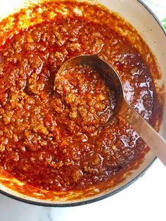 a pot filled with chili sauce on top of a table