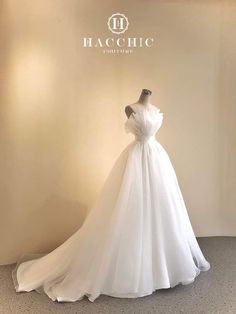 a white wedding dress on display in front of a wall