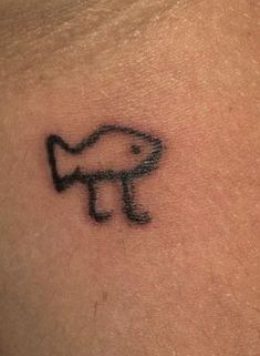 a tattoo on the back of a person's shoulder with an image of a fish coming out of it