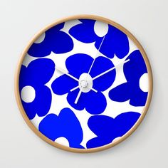 a clock with blue and white flowers on it's face, showing the time