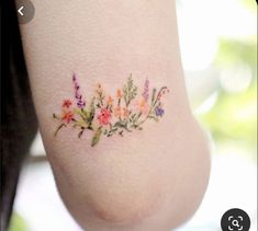 a woman's foot with flowers painted on the bottom of her leg and an arm