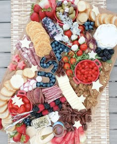 a platter filled with cheese, crackers and fruit