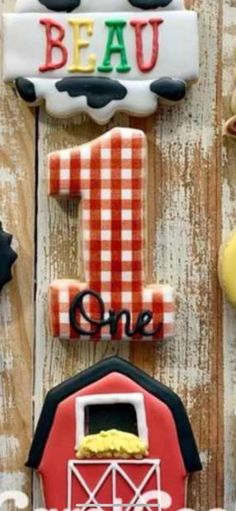 decorated cookies are displayed on the side of a wooden fence, including one that says 1