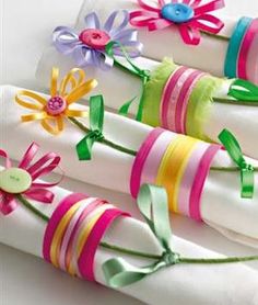 four napkins decorated with ribbons and flowers on top of each other in different colors