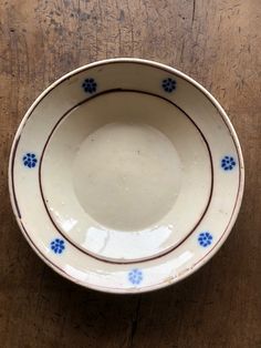 a white and blue bowl sitting on top of a wooden table