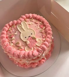 there is a pink cake with white frosting and an image of a bunny on it