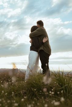 two people embracing each other in a field