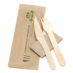 two wooden utensils sitting on top of a piece of paper next to a bag