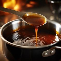 a spoon full of liquid being poured into a pot