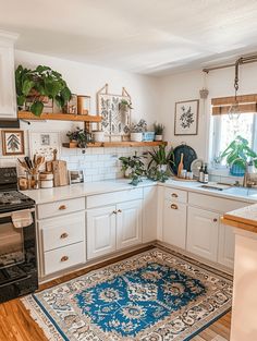 a kitchen with white cabinets and an area rug on the floor in front of the stove