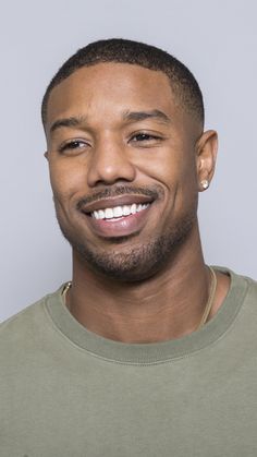 a close up of a person with a smile on his face and wearing a green shirt