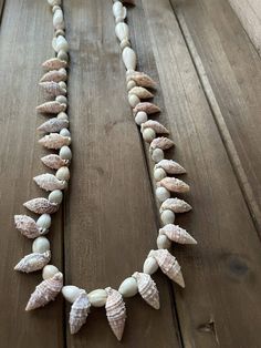 a necklace made out of seashells on a wooden table